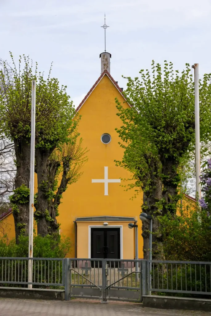Straßenansicht der kleine gelben Filialkirche in Kirchhain