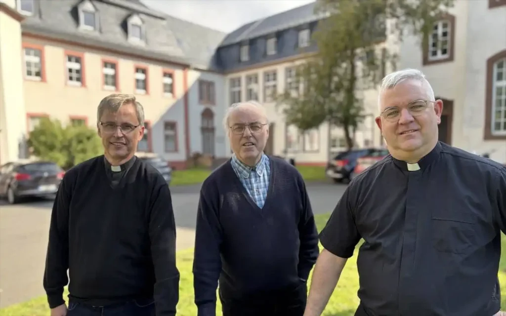 Vinzentiner-Patres in Niederprüm stehend vor einem Gebäude